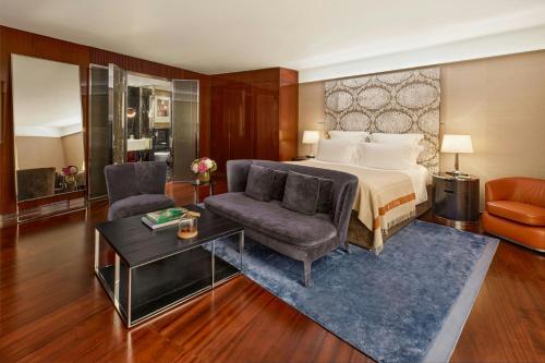 a bedroom with a bed and a chair and a table at Bvlgari Hotel London in London