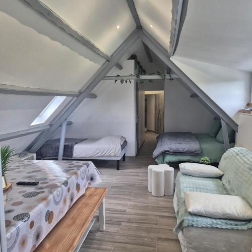 Cette chambre mansardée comprend deux lits et un canapé. dans l'établissement maison 6 7 p avec piscine, à Les Sables-dʼOlonne