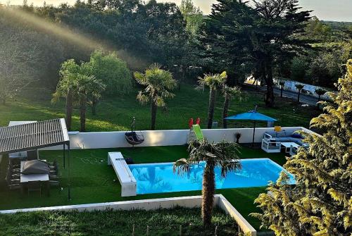 une vue aérienne d'une piscine avec des palmiers dans l'établissement maison 6 7 p avec piscine, à Les Sables-dʼOlonne