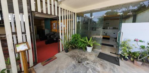 a house with glass doors and plants in it at One World Mirissa in Mirissa