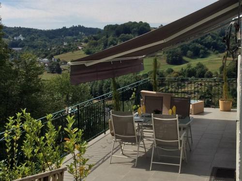 a patio with a table and chairs on a balcony at Suite panoramique à Tulle in Tulle