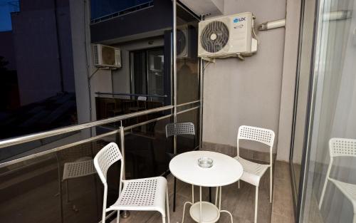 a balcony with a table and chairs and a heater at Downtown Accommodation in Bucharest