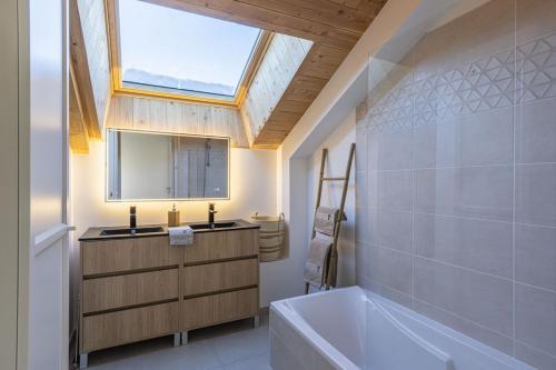 La salle de bains est pourvue d'une fenêtre, d'une baignoire et d'un lavabo. dans l'établissement New T4 type chalet SerreChevalier face téléphérique, à Briançon