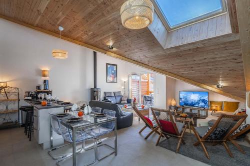un grand salon avec un plafond voûté et un salon dans l'établissement New T4 type chalet SerreChevalier face téléphérique, à Briançon