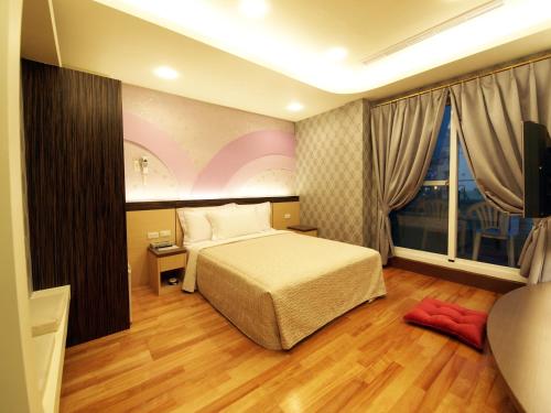 sypialnia z łóżkiem i dużym oknem w obiekcie Ibizakenting Hotel II w Kenting
