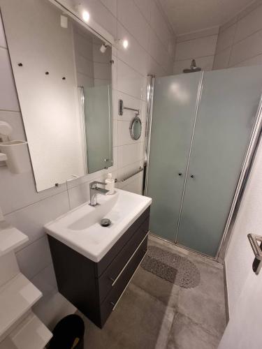 une salle de bain blanche avec un lavabo et une douche dans l'établissement Superbe appartement entièrement rénové 4EST211, au Barcarès