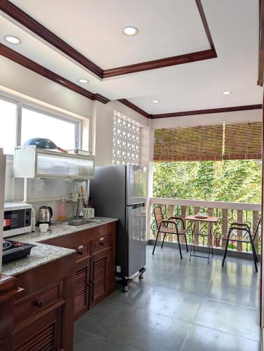 a kitchen with a stainless steel refrigerator and a balcony at VILLA Siem Reap - eco & local in Siem Reap