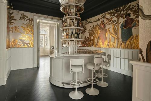 a bar with stools in a room with a painting at W Budapest in Budapest