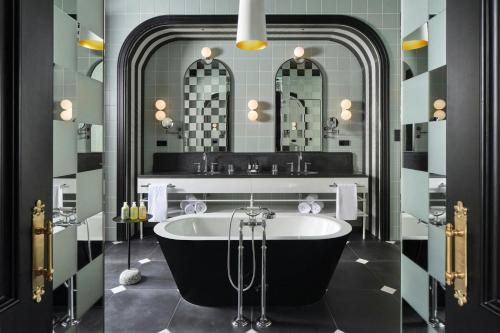 a bathroom with a tub and a large mirror at W Budapest in Budapest