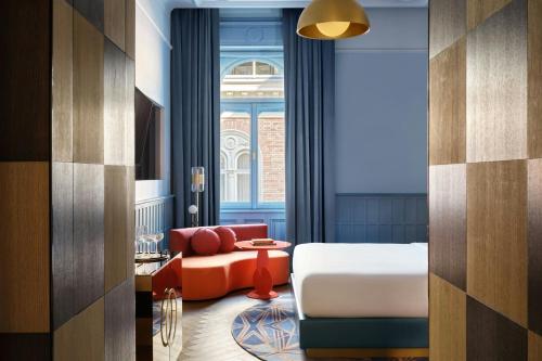 a room with a bed and a couch and a window at W Budapest in Budapest