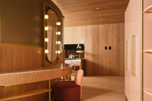 a bathroom with a vanity with a chair and a mirror at W Budapest in Budapest