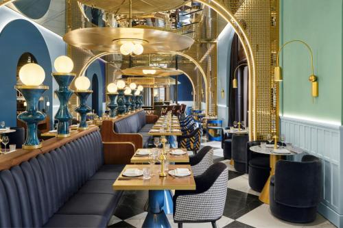 a restaurant with blue walls and tables and chairs at W Budapest in Budapest