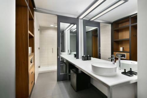 a bathroom with two sinks and a large mirror at Aloft Greenville Downtown in Greenville