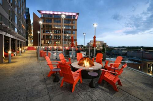 a patio with chairs and a table with a fire place at Aloft Greenville Downtown in Greenville