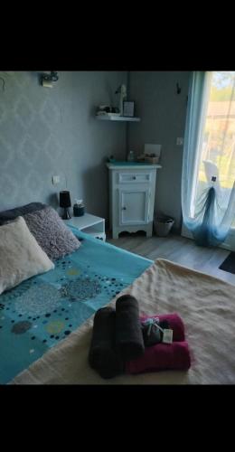 une chambre avec un lit avec une couverture bleue et une fenêtre dans l'établissement Agréable chambre d' hôte avec accès piscine, à Septfonds