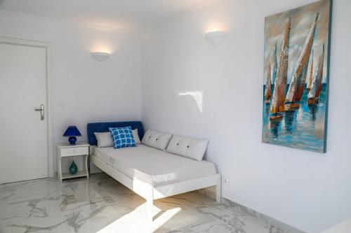 a white couch in a white room with a painting at Mediterranean Beauty in Skiathos