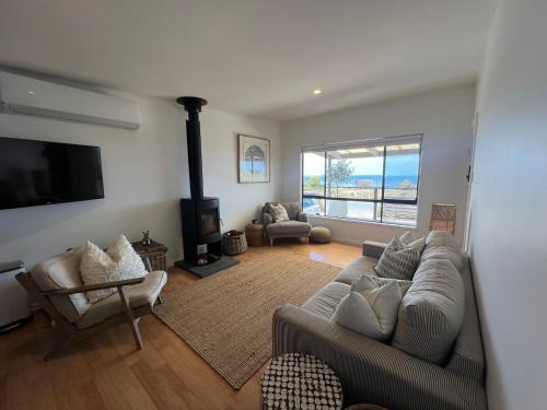 Una sala de estar con un sofá y una chimenea. en Waters Edge, en Marion Bay