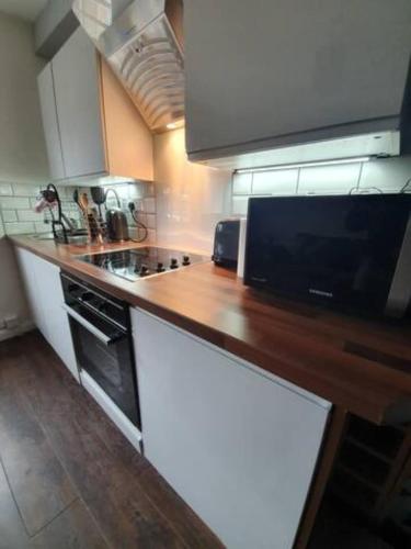 a kitchen with a wooden counter top with a stove at Cosy Mews House, Heart of Mumbles gateway to Gower in The Mumbles