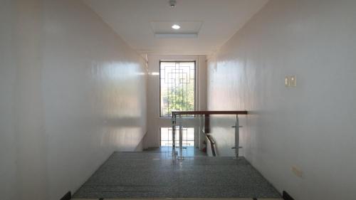 an empty hallway with a window and a stair case at Bliss Hotel San Fernando Pampanga City in San Fernando
