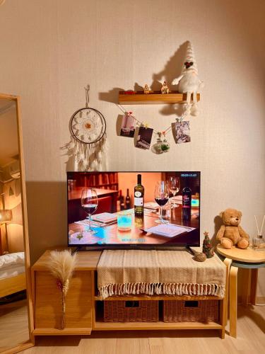 a flat screen tv sitting on a table with wine glasses at KSPO,JYP,LotteTower, Sodamjae Stay in Seoul