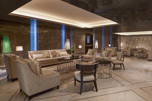 a hotel lobby with couches and chairs and tables at Renaissance Dhaka Gulshan Hotel in Dhaka