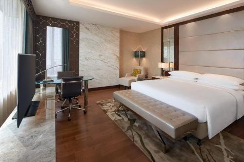 a hotel room with a large bed and a desk at Renaissance Dhaka Gulshan Hotel in Dhaka