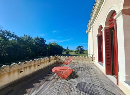 a pair of chairs sitting on a balcony at Séjour d'exception, charme, histoire sud Touraine in Richelieu