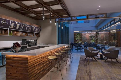 a restaurant with a bar with chairs and tables at Courtyard by Marriott Guatemala City in Guatemala