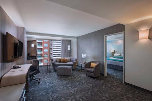 a hotel room with a bed and a living room at Courtyard by Marriott Guatemala City in Guatemala