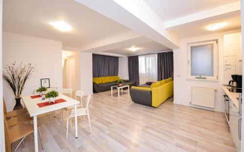 a living room with a yellow couch and a table at Downtown Accommodation in Bucharest