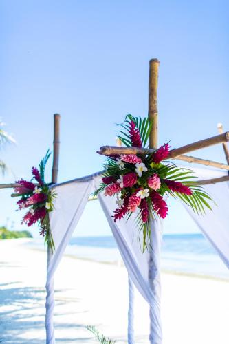 a wedding altar on the beach with flowers at Plantation Island Resort in Malolo Lailai