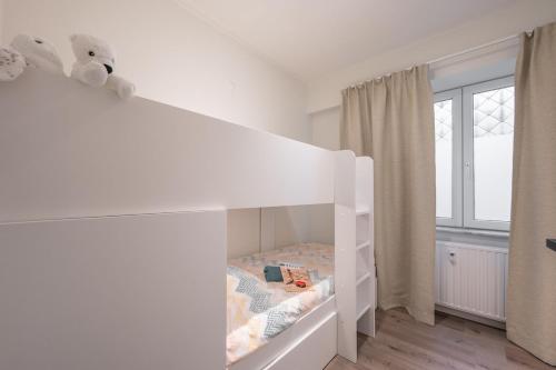 a white bunk bed in a childs bedroom at kindvriendelijk appartement "Sereno", De Haan-Wenduine in Wenduine