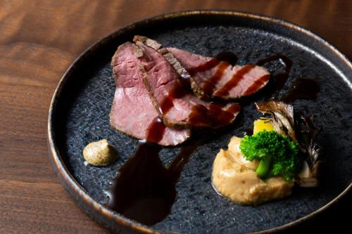 a plate of food with meat and broccoli on a table at Courtyard by Marriott Fukui in Fukui