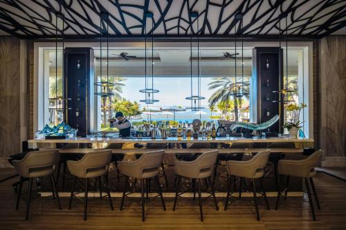a bar in a restaurant with a view of the ocean at Renaissance Danang Hoi An Resort & Spa in Hoi An