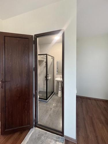 a bathroom with a glass door and a toilet at Mandarini in Chakvi
