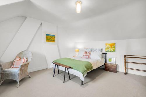 a bedroom with a bed and a chair in it at Historic 4 Bedroom Townhouse in Launceston