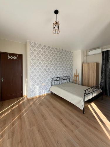 a bedroom with a bed and a wooden floor at Mandarini in Chakvi