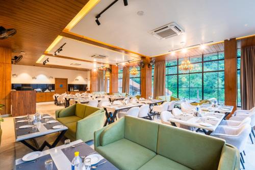 a restaurant with tables and chairs and windows at DLS Divine River Resort and Spa, Rishikesh in Rishīkesh