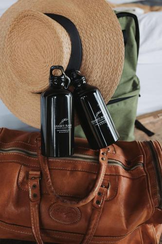 a hat and two bottles on top of a purse at Nambiti Plains Lodge in Nambiti Private Game Reserve