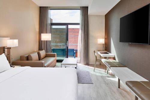 a hotel room with a bed and a television at AC Hotel by Marriott Greenville in Greenville