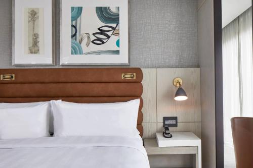 a bedroom with a bed and two pictures on the wall at AC Hotel by Marriott Greenville in Greenville