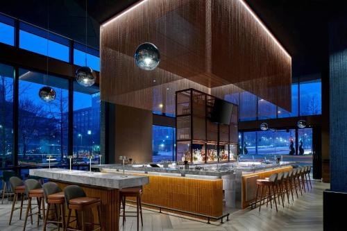 a bar in a building with chairs and tables at AC Hotel by Marriott Greenville in Greenville
