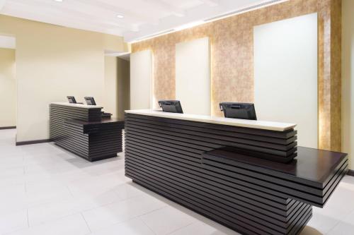 a lobby with two reception desks with chairs at Courtyard by Marriott Kingston, Jamaica in Kingston