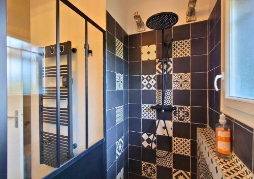 La salle de bains est pourvue d'une douche et de carrelage noir et blanc. dans l'établissement VILLA TOURTERELLE - A vous la dolce vita, à Soorts-Hossegor