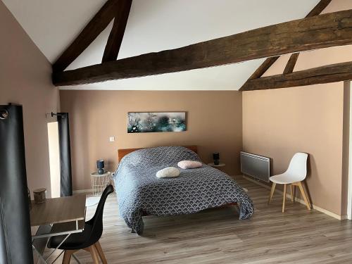 a bedroom with a bed and a table and chairs at La Maison Majorelle in Bar-sur-Aube