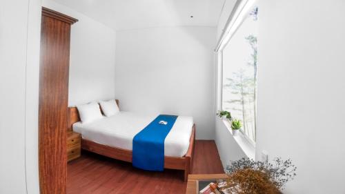 a small bedroom with a bed and a window at Le Huynh Mui Ne Hotel in Mui Ne