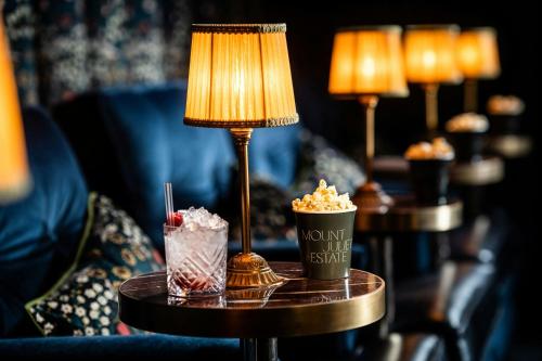 a table with two drinks and a lamp on it at Mount Juliet Estate, Autograph Collection in Thomastown