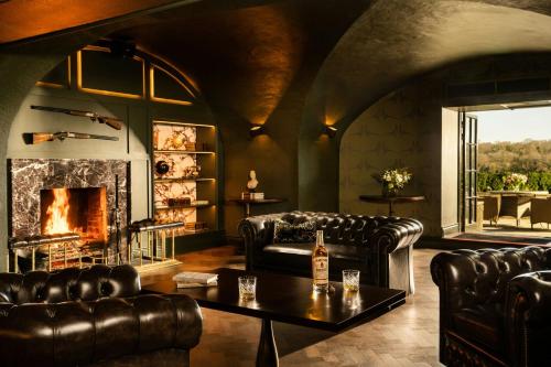 a living room with leather furniture and a fireplace at Mount Juliet Estate, Autograph Collection in Thomastown