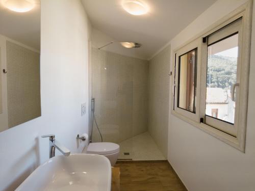 une salle de bain avec un lavabo et des toilettes et une fenêtre dans l'établissement Attic With a View, à Fluminimaggiore
