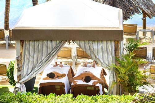 a group of four beds on the beach at Renaissance Wind Creek Curacao Resort in Willemstad